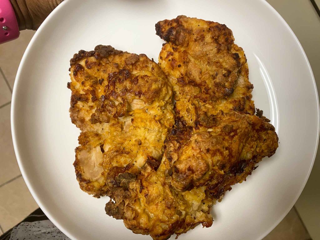three pieces of air fryer fried chicken on a white plate in kitchen