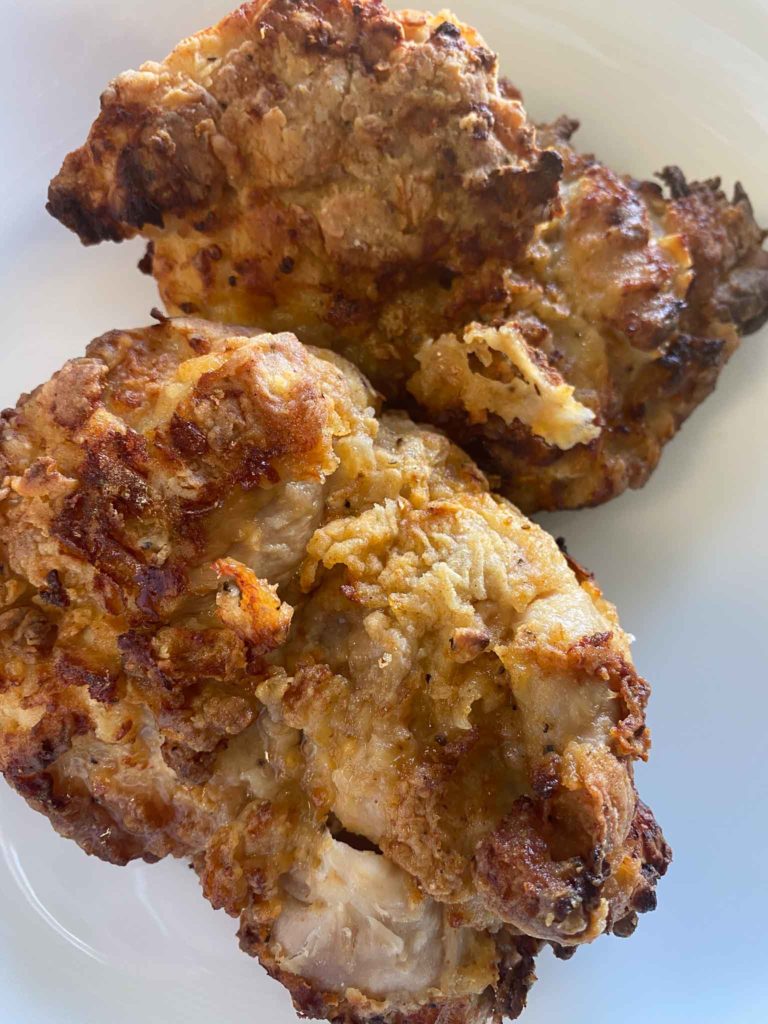two pieces of air fryer fried chicken on a white plate